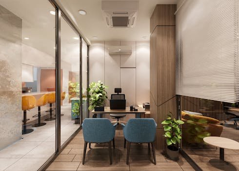 A stylish, modern office interior featuring a meeting area with blue chairs and wooden accents.