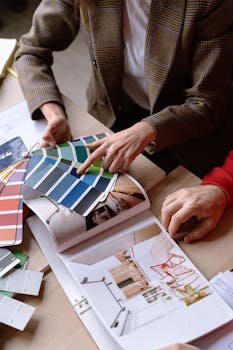 Interior designers discuss color swatches and design ideas at a table, planning a creative project.