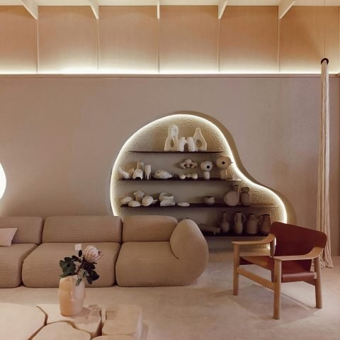 A beige modern living room with minimal decor and creative lighting, located in SP, Brazil.