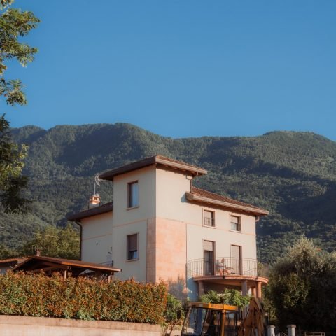 A serene villa against Lombardy's picturesque mountains in Colico, Italy.